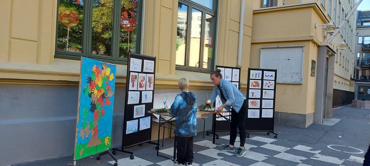 en person og en person som står ved siden av et bord med plakater på en person og en person som står ved siden av et bord med plakater på